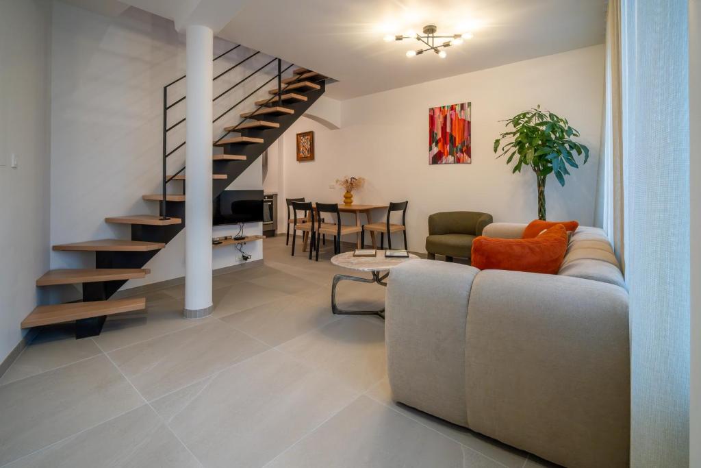 un soggiorno con divano e una scala a chiocciola di Maison alsacienne a Sélestat