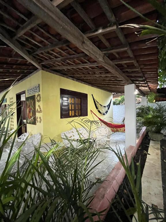 a house with a patio with a hammock in it at Casa Simples e Charmosa na Praia de Ipioca in Maceió