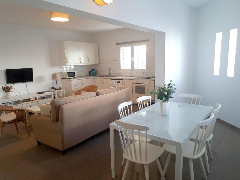 Una sala de estar y una cocina con un sofá y una mesa. en Beach House Arinaga, en Arinaga