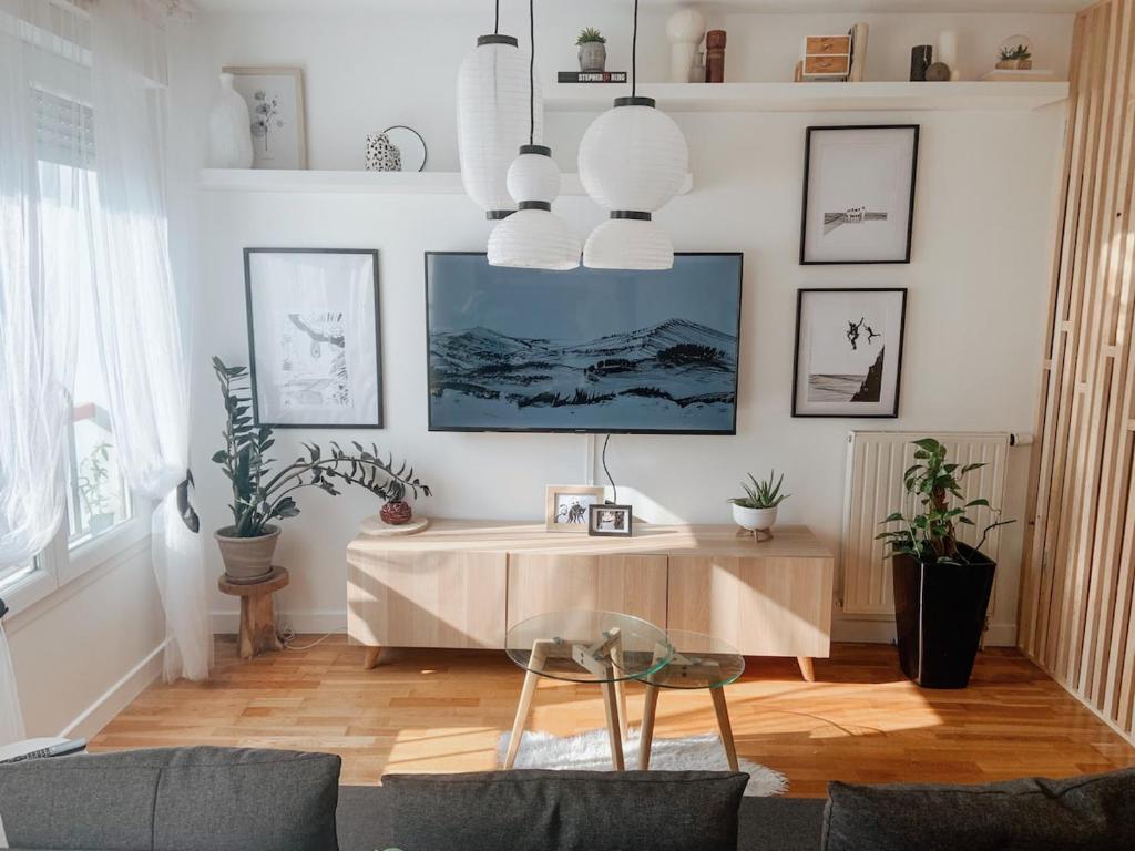 un salon avec une table et des plantes dans l'établissement Appartement avec une place de parking, à Hendaye