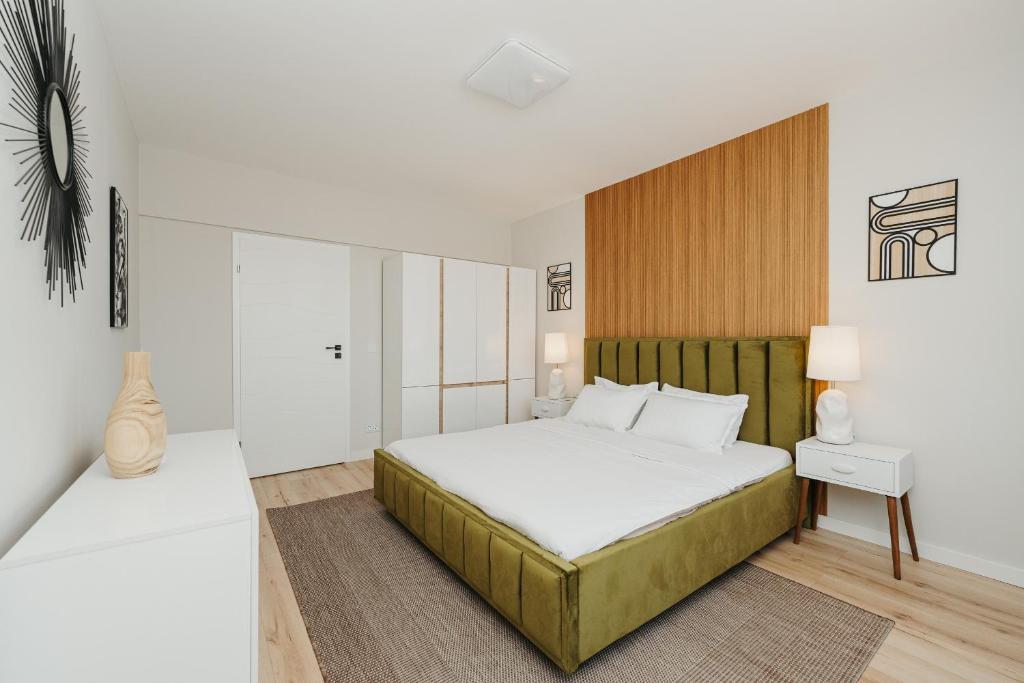 a bedroom with a large bed with white sheets at Lavender Nest 6 - Hiperbara - Livezeni - 2BR in Livezeni