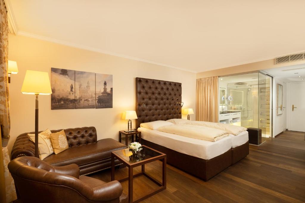 una camera d'albergo con un letto e un divano di Hotel Friesacher ad Anif