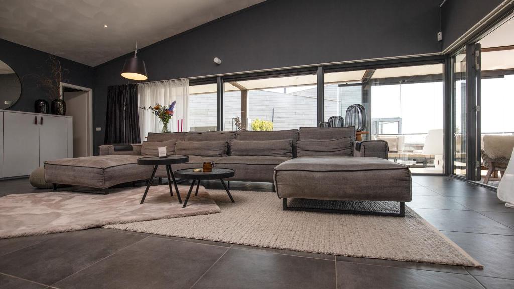 una sala de estar con un sofá y una mesa en Villa Super VIP - 4 Pers met jacuzzi - Villa 7, en Ouddorp
