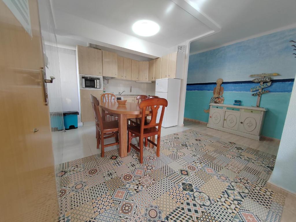 a kitchen with a table and chairs in a room at Tout près de la plage in Puerto de Sagunto