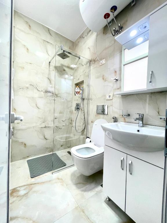 Un baño con ducha, inodoro y lavabo. en Centrum Hotel, en Tirana
