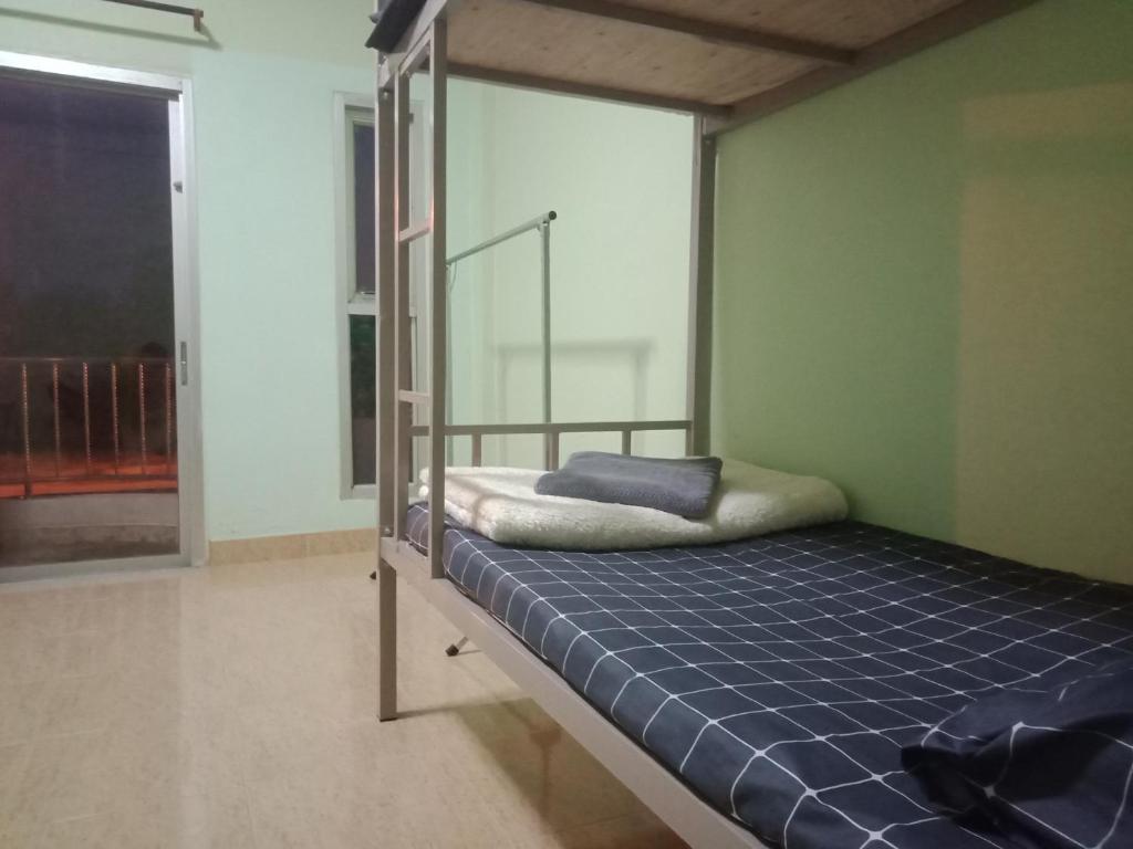 a bedroom with a bunk bed with a blue mattress at มังกรเลโฮสเทล Mangkonlay Hostel in Ban Khlong Pak