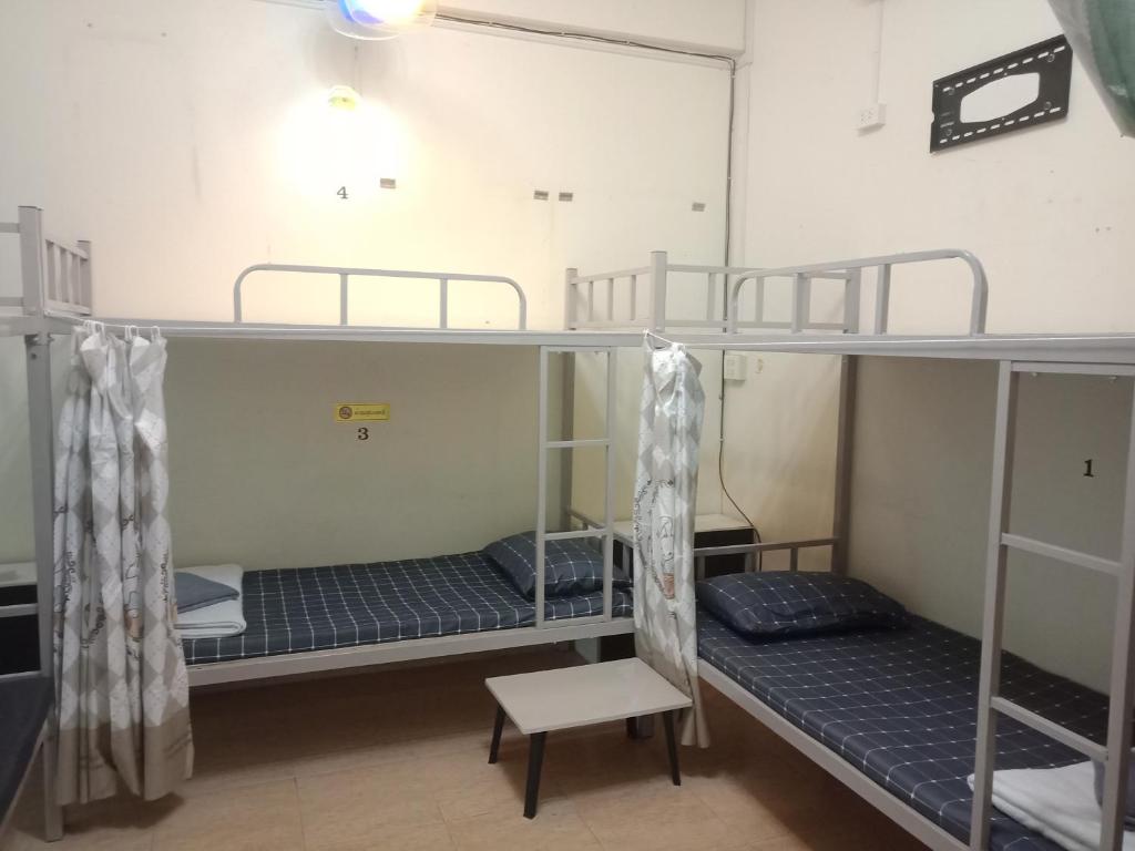 a room with two bunk beds and a chair at มังกรเลโฮสเทล Mangkonlay Hostel in Ban Khlong Pak