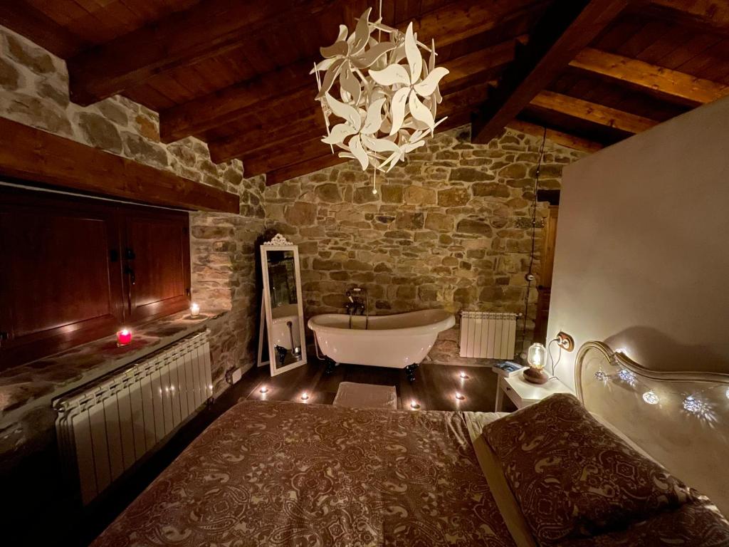 a bathroom with a bath tub and a chandelier at Cabaña Pasiega El Ojal B in San Pedro del Romeral