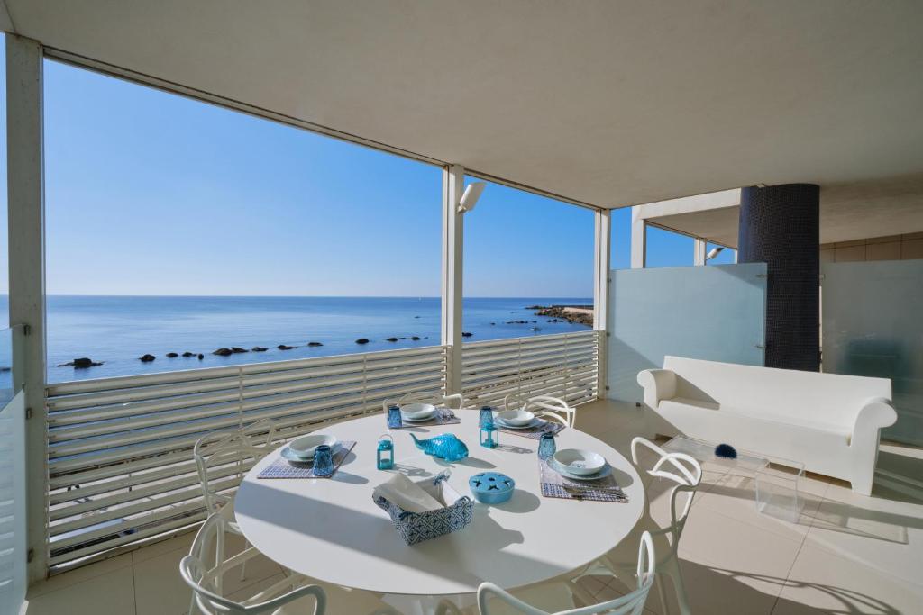 een witte eetkamer met uitzicht op de oceaan bij Terrazza Giudecca Gallipoli in Gallipoli