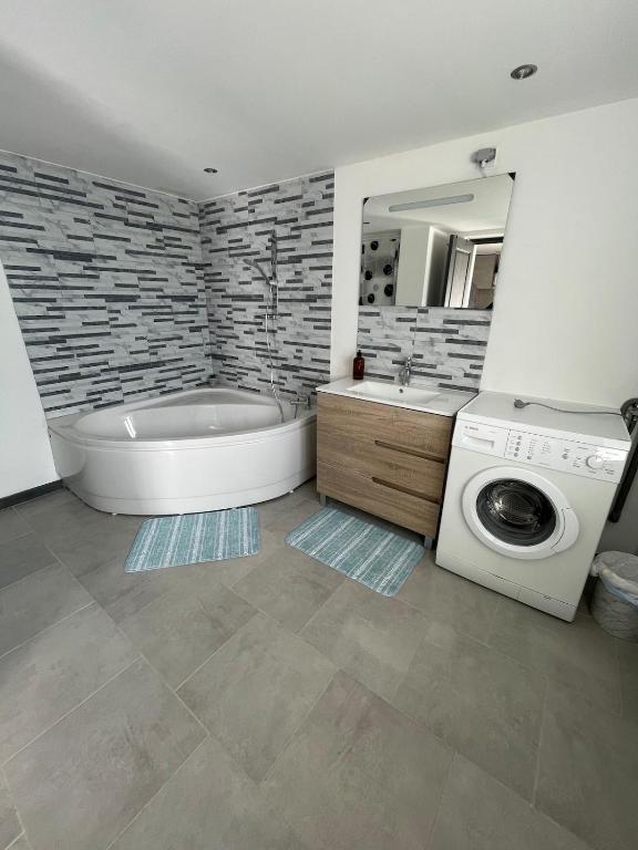 ein Badezimmer mit Badewanne und Waschmaschine in der Unterkunft Warm home in Madonne-et-Lamarey