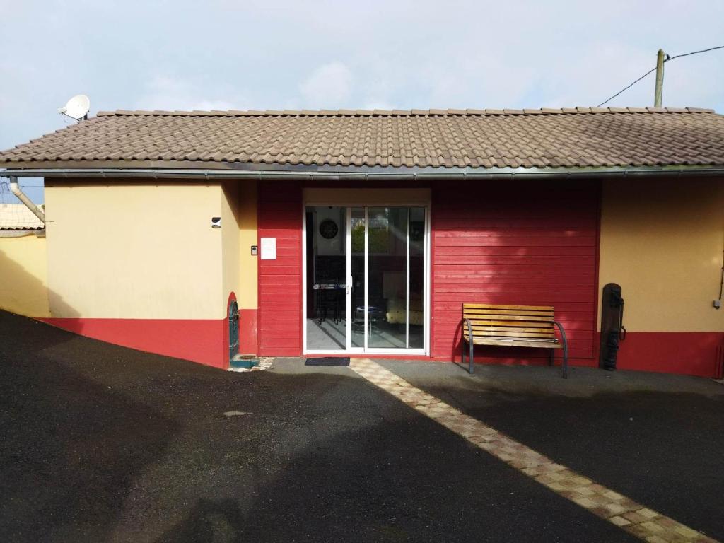 un bâtiment rouge avec un banc devant lui dans l'établissement Gîte entre fécamp et etretat, à Mentheville