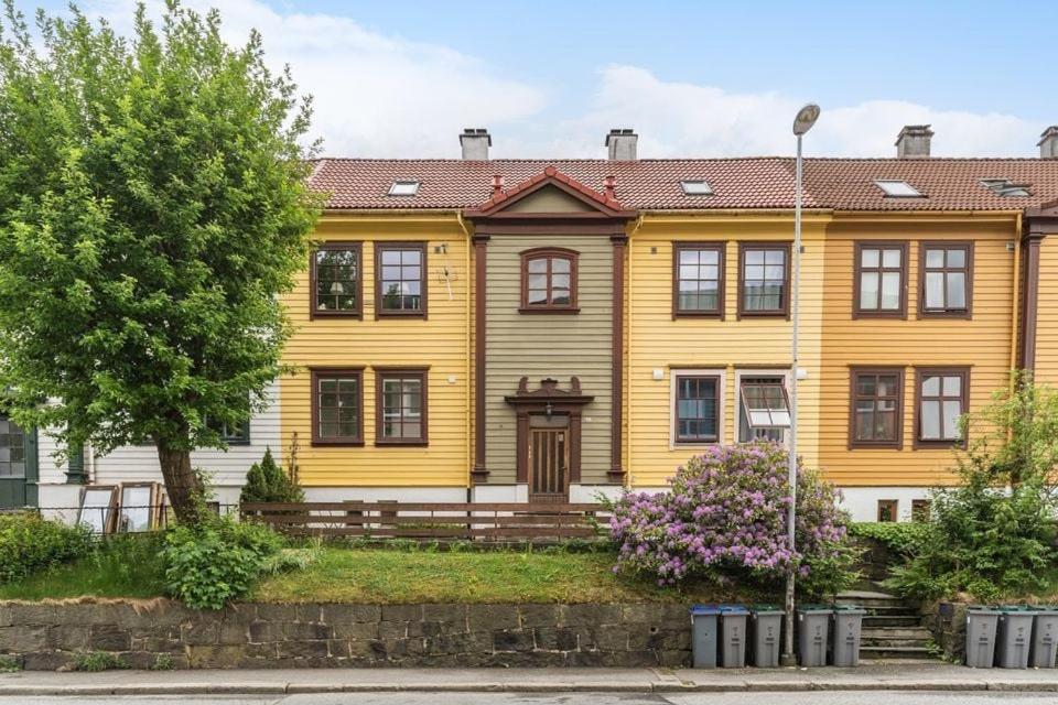 una casa gialla con un albero di fronte di Urban retreat, traditional wooden house in Bergen a Bergen