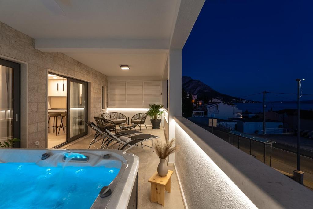 a hot tub on the balcony of a house at night at Luxury Tommy's Apartment in Duće