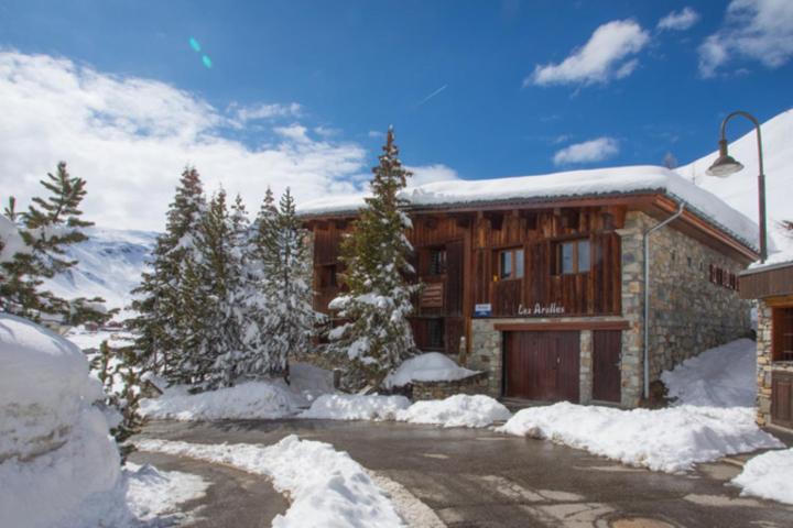 Chalet Les Arolles- Catered Chalet -Half Board في تينيِ: منزل فيه ثلج على الأرض أمامه