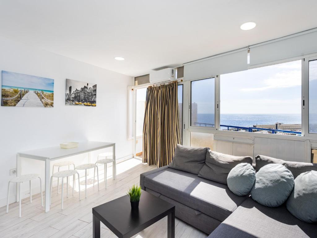 uma sala de estar com um sofá e uma mesa em Live Candelaria Serviola with balcony em Candelaria