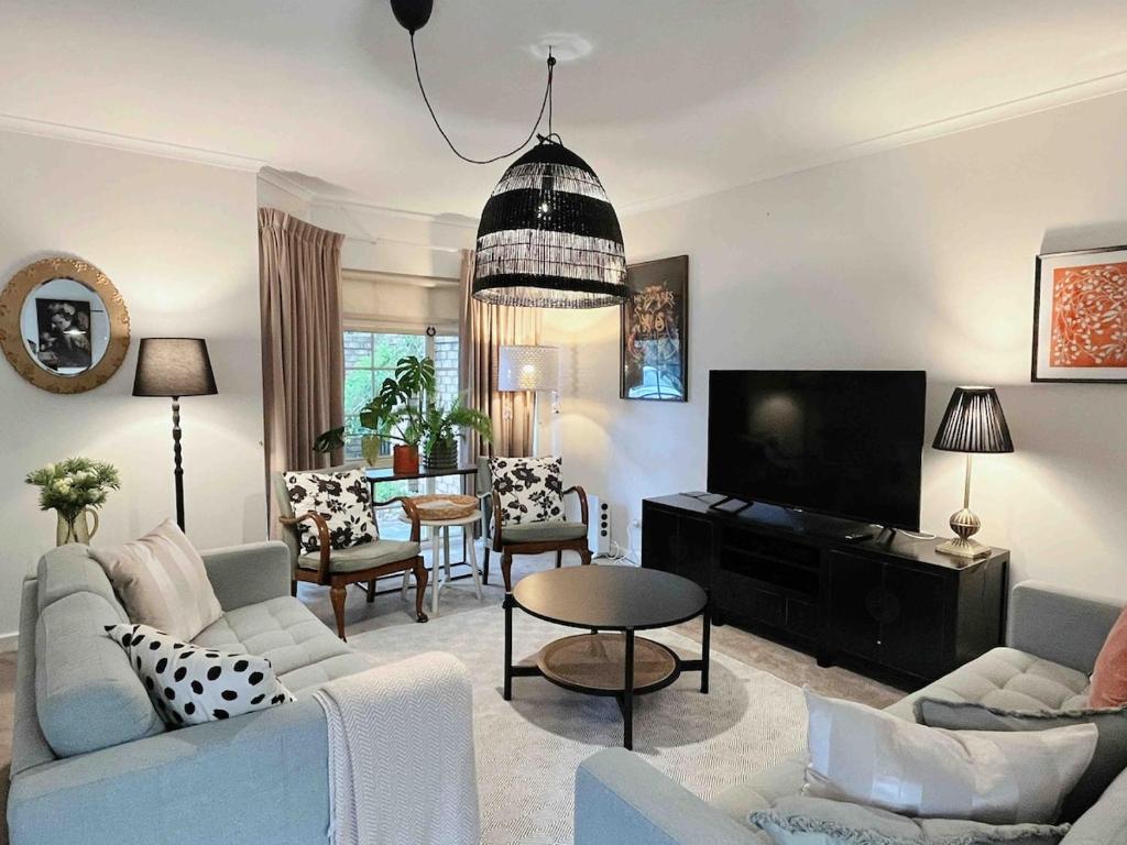 ein Wohnzimmer mit Sofa und Fernseher in der Unterkunft Peaceful cottage Burnside area in Burnside