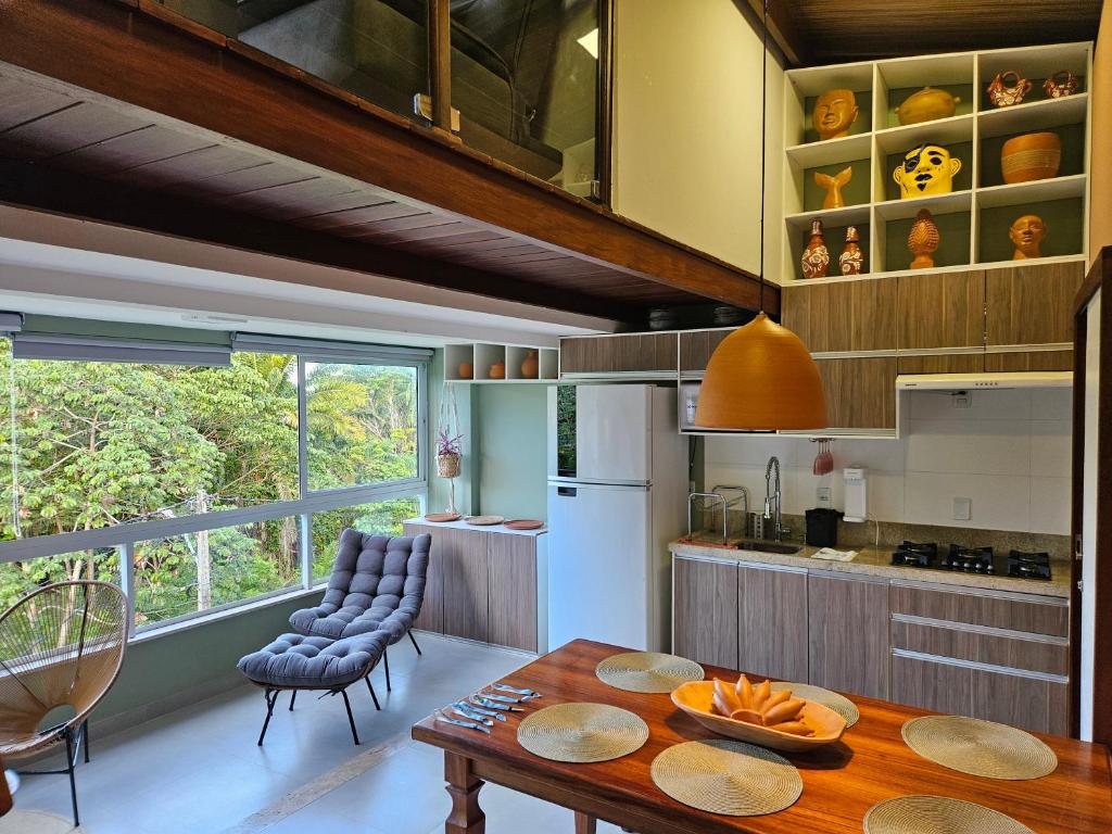 a kitchen with a table and chairs and a refrigerator at Casa Absolute Summer Breeze e Piscina in Morro de São Paulo