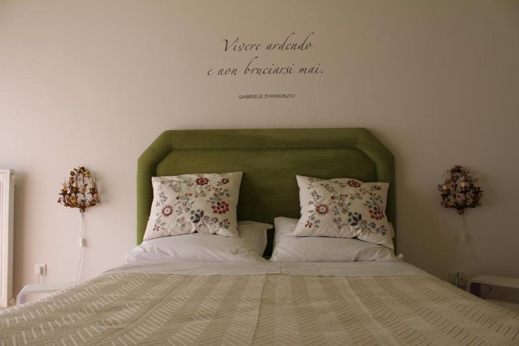 a bed with two pillows and a sign that says your alphabet are our breakfast at La Dimora del Conte in Pescara