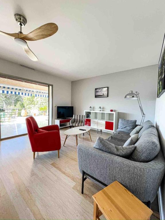 - un salon avec un canapé et un fauteuil rouge dans l'établissement L'HORIZON - 90m2 - Belle vue - Centre - Parking - 3 Chambres, à Cassis