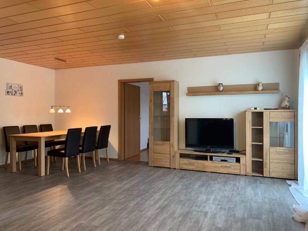 a dining room with a table and a television at Ferienwohnung Ortenau in Neuried