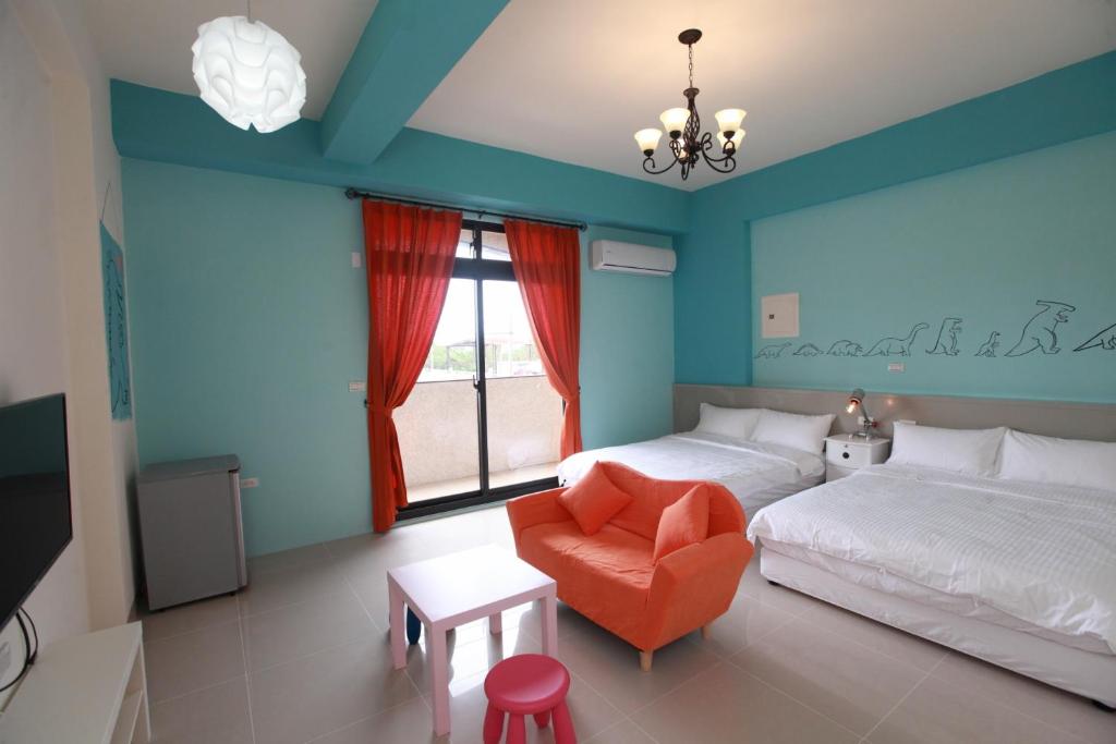 um quarto com paredes azuis e uma cama e uma cadeira em This Home B&B em Jian