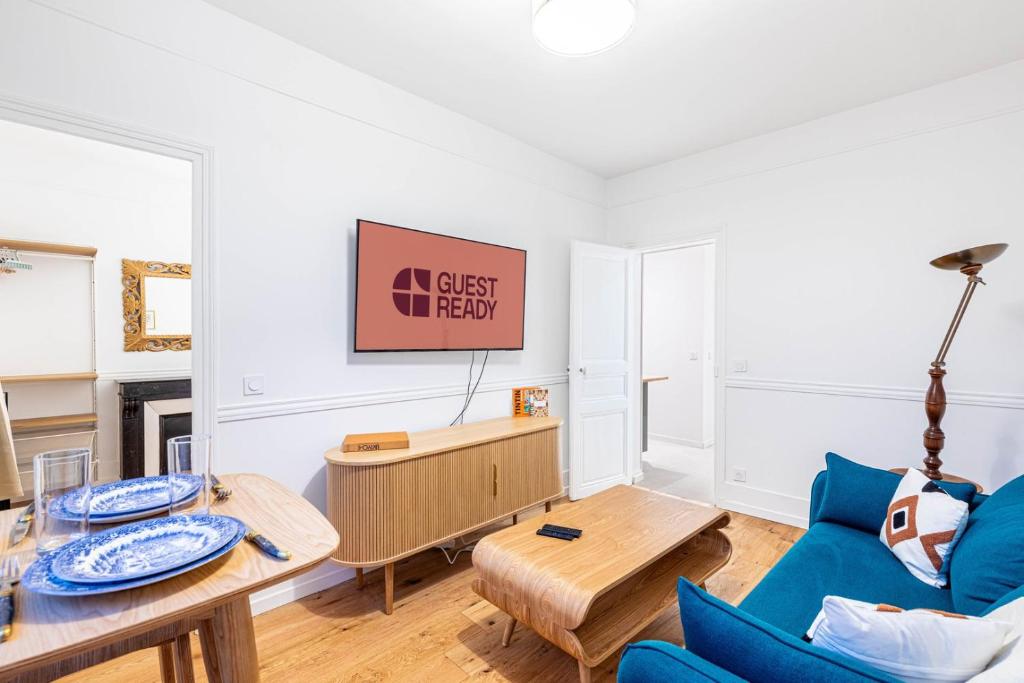 un salon avec un canapé bleu et une table dans l'établissement GuestReady - Charming Getaway in Paris 15th, à Paris