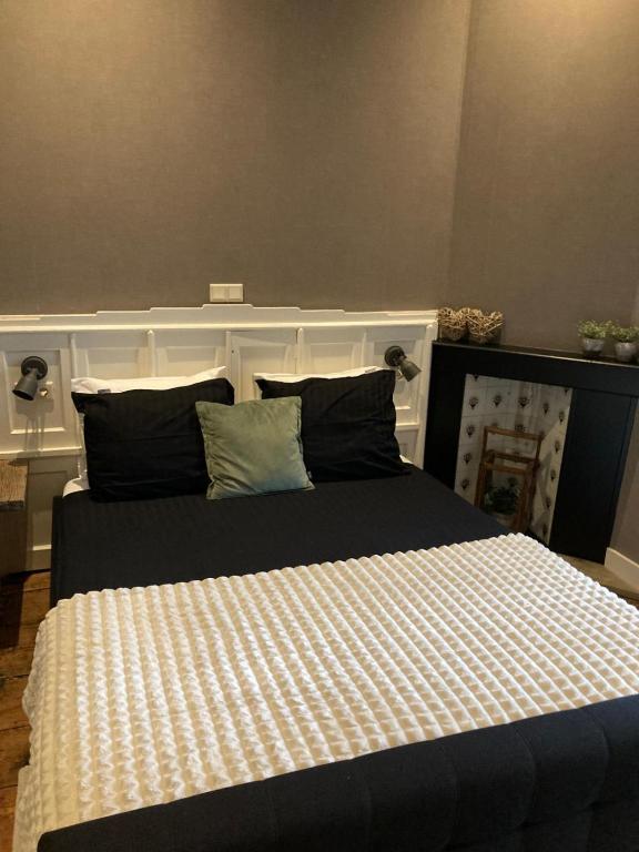 een slaapkamer met een bed met een wit en zwart dekbed bij Logement De drie stokvisschen in Middelburg