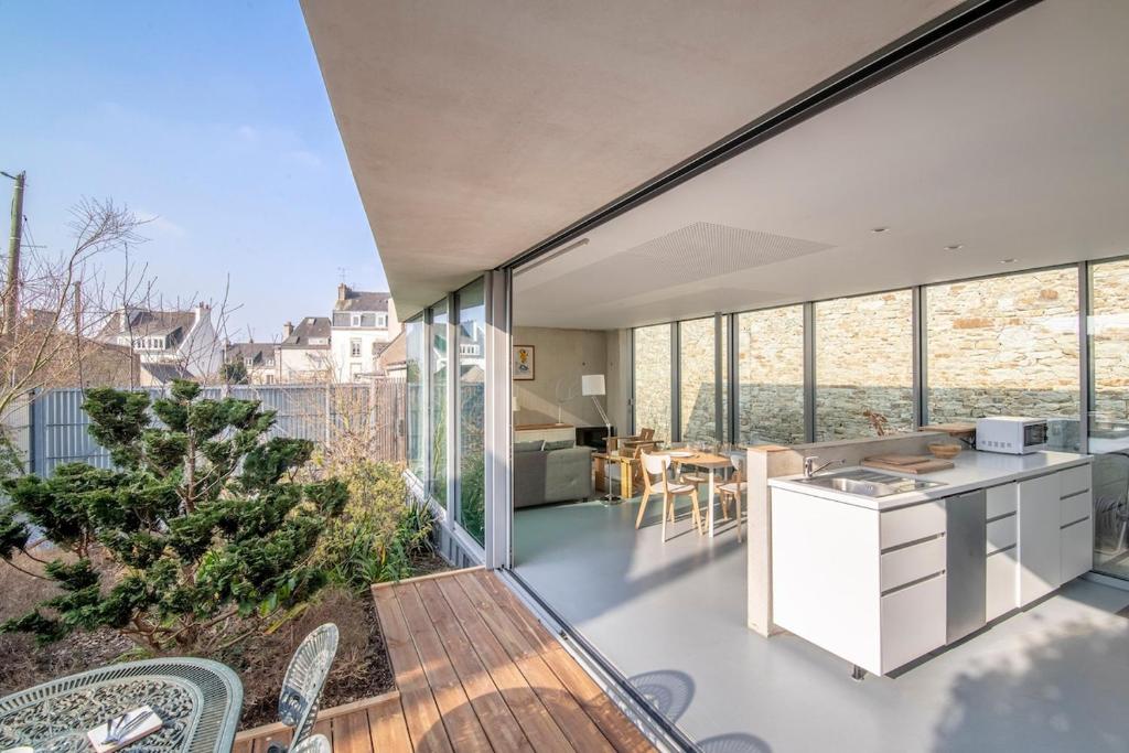 eine offene Küche und ein Esszimmer eines Hauses mit Fenstern in der Unterkunft Habiter la ville, un art contemporain in Vannes