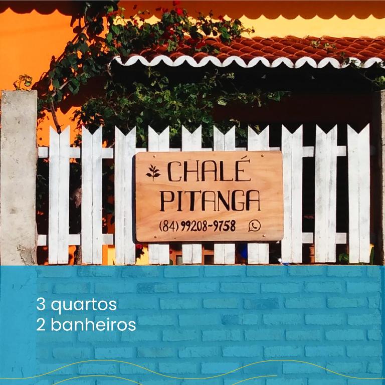 a white picket fence with a sign that reads chile primer at Chalé Pitanga in São Miguel do Gostoso
