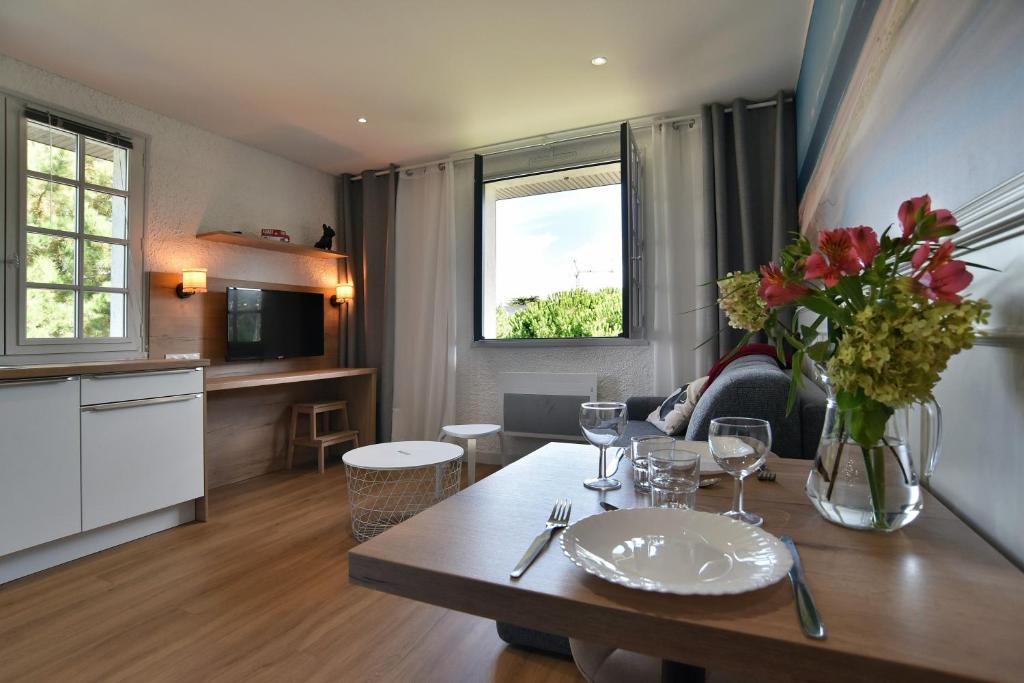 Una sala de estar con una mesa con un jarrón de flores. en Cécile 11 - A 200m de la plage, en Fréhel