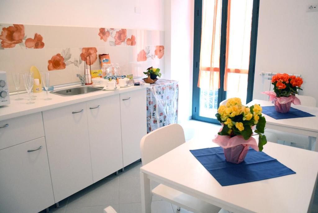 eine Küche mit einem Tisch und einer Blumenvase darauf in der Unterkunft Grigio Pesca in Salerno
