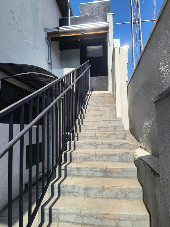 a staircase leading up to a building with a door at Apartamento 1 andar in Bebedouro