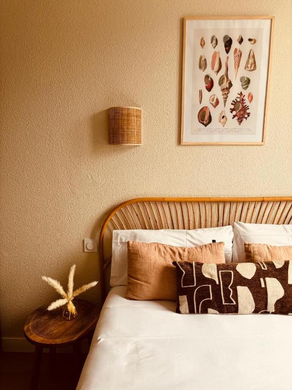 a bedroom with a bed with pillows and a table at Hôtel Le Britannic in Saint Malo