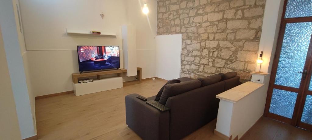 a living room with a couch and a tv at Casa vacanze Pabaule in Gonnesa