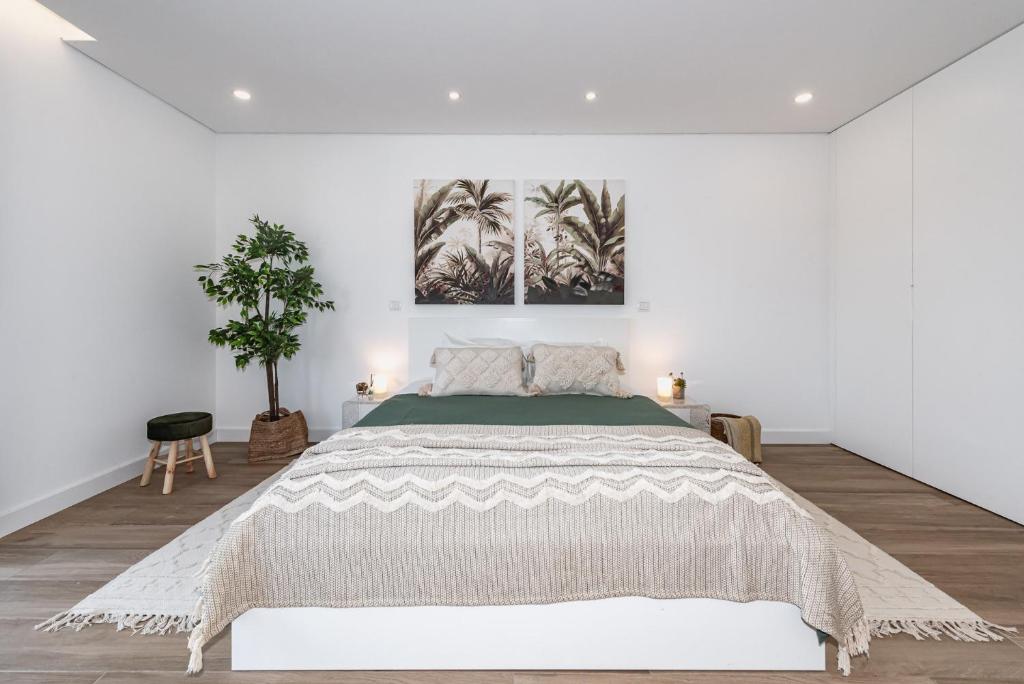 a white bedroom with a large bed in a room at Casa da Oliveira ~ Azeitão in Azeitao