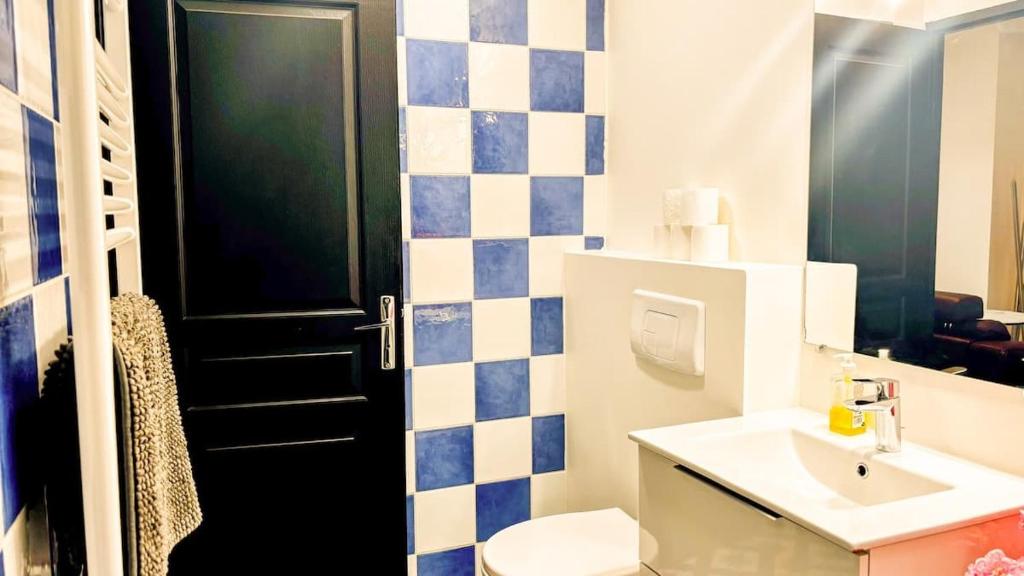 La salle de bains est pourvue d'une porte noire et d'un lavabo. dans l'établissement T3 pleincentre airconditionné, à Bordeaux
