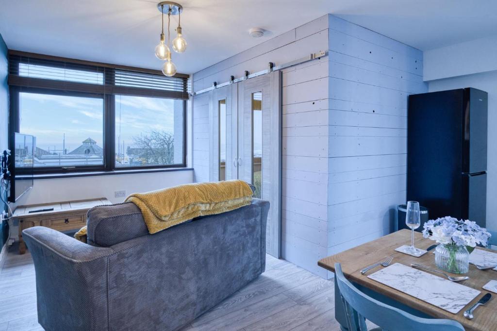 a living room with a couch and a table at Driftwood Den - 1 Bedroom Apartment - Saundersfoot in Saundersfoot