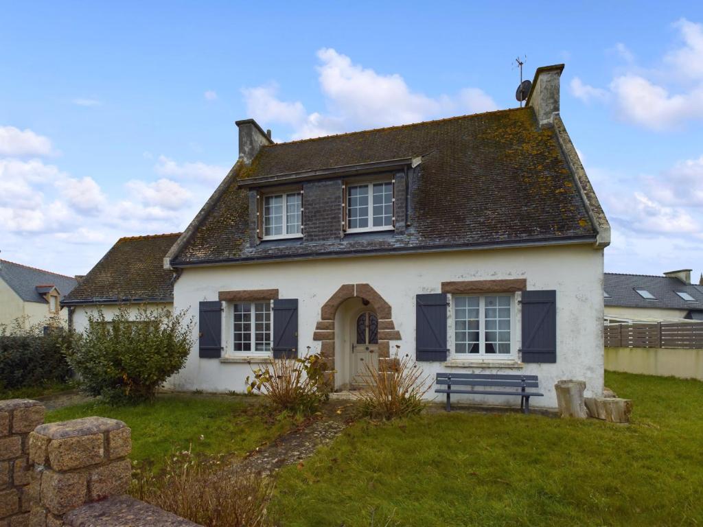 une maison blanche avec un banc dans la cour dans l'établissement Authentique maison bretonne pour 6 à Plovan, à Plovan
