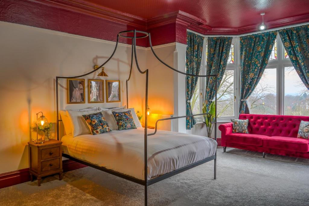 a bedroom with a bed and a red couch at The Newcastle Residence Cozy & Modern Flats in The Park Estate in Nottingham