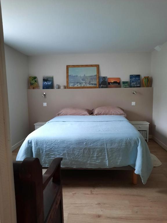une chambre avec un lit avec une couette bleue dans l'établissement Giverny, Cosy studio au vert, à Giverny