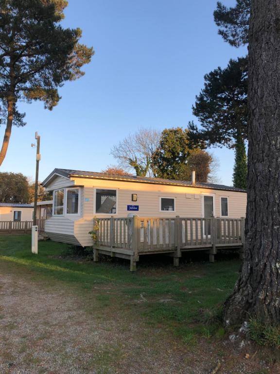 a yellow caravan parked next to a tree at Mobil Home, 4 places 2 chambres, camping 4 étoiles, Bretagne, sud Finistère in Clohars-Carnoët