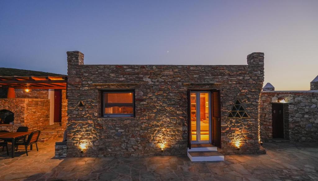 a stone house with lights on a patio at Onar Sifnos Stone Villa in Sifnos