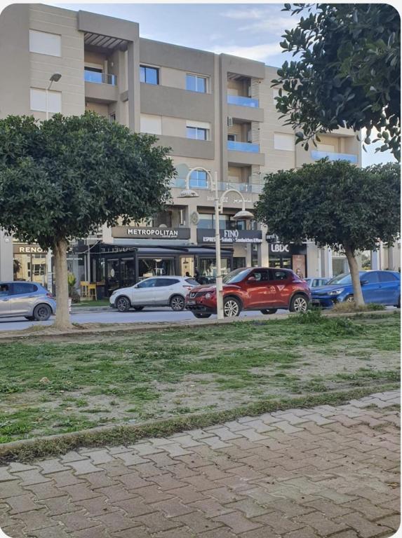 a parking lot with cars parked in front of a building at Dar Kmar 2 in Tunis
