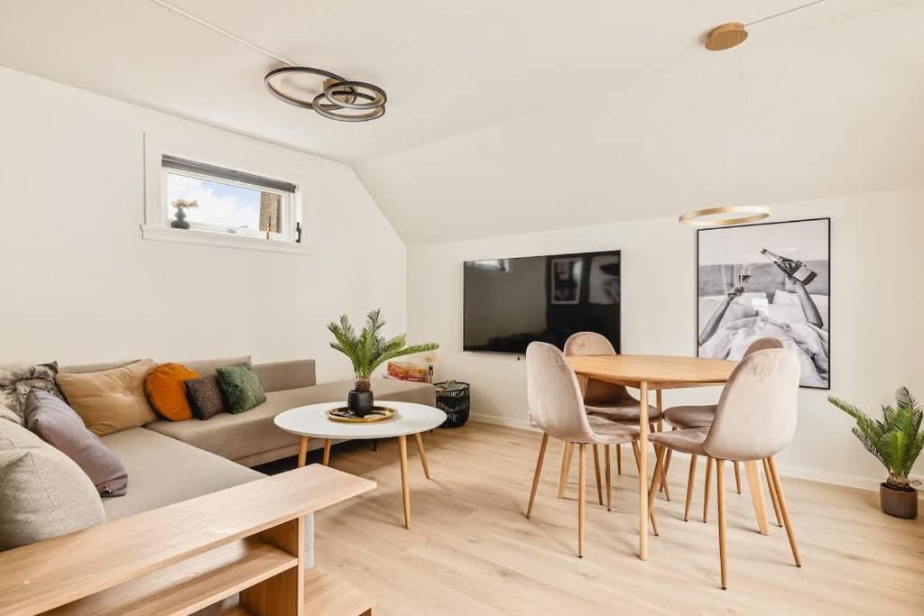 a living room with a table and chairs and a couch at DINBNB Apartment l Skansen funhouse - 400m to Bryggen Gym & Parking in Bergen