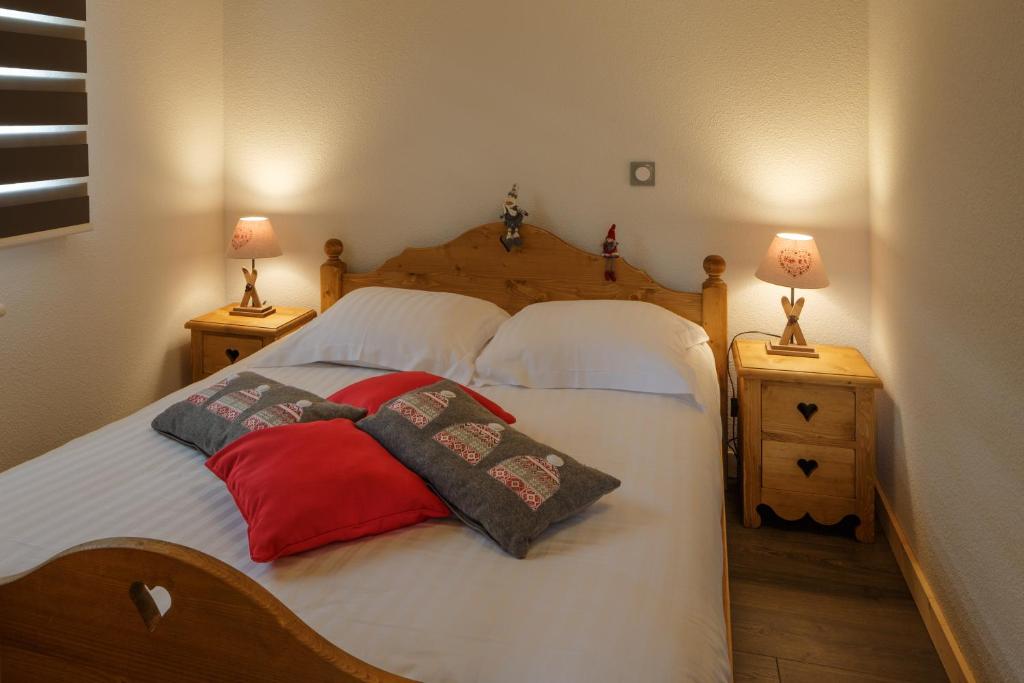 une chambre avec un lit avec deux oreillers dessus dans l'établissement Dvacances Résidence les tavaillons, à Mijoux