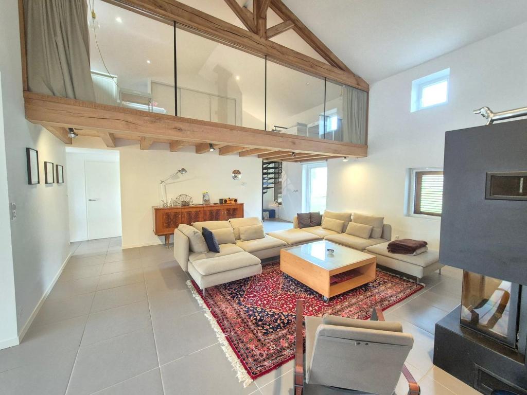 ein Wohnzimmer mit Sofa und Tisch in der Unterkunft Maison "Chalet Concept" 6 pers à 10min Puy du Fou in La Gaubretière