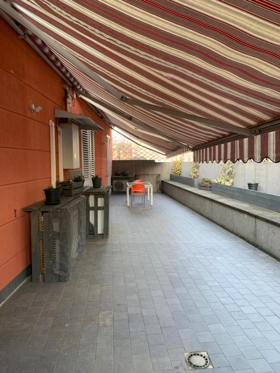 an outdoor patio with awning and a table and chairs at La Terrazza in San Giovanni Valdarno