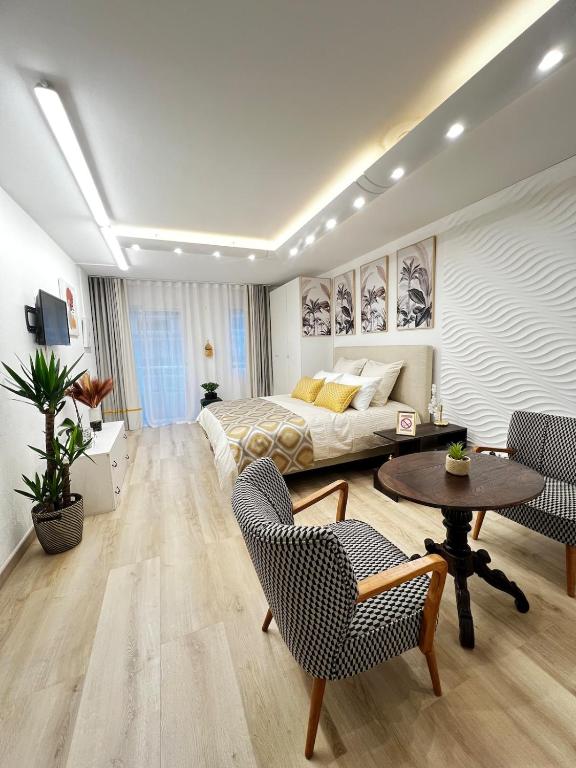 une chambre avec un lit, une table et des chaises dans l'établissement Appartement Monaco Palais Joséphine, à Beausoleil