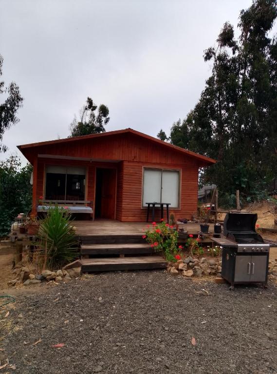 a small house with a porch and a grill at Cabaña en el bosque in La Ligua
