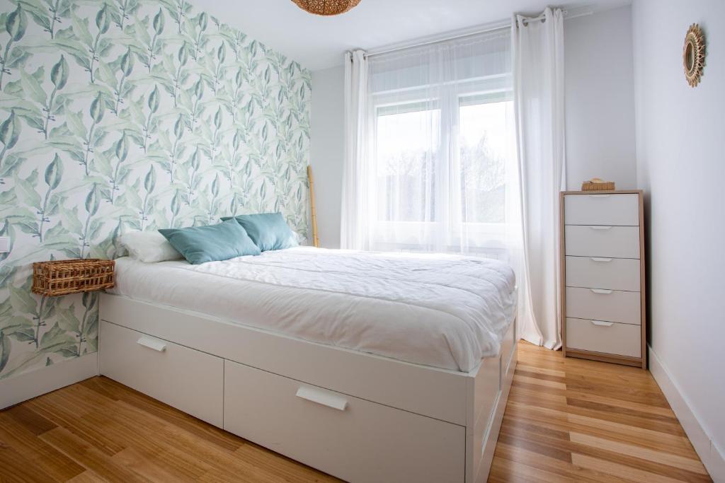 une chambre avec un lit et une peinture murale dans l'établissement Apartamento Urdaibai Busturia cerca de la playa, à Busturia